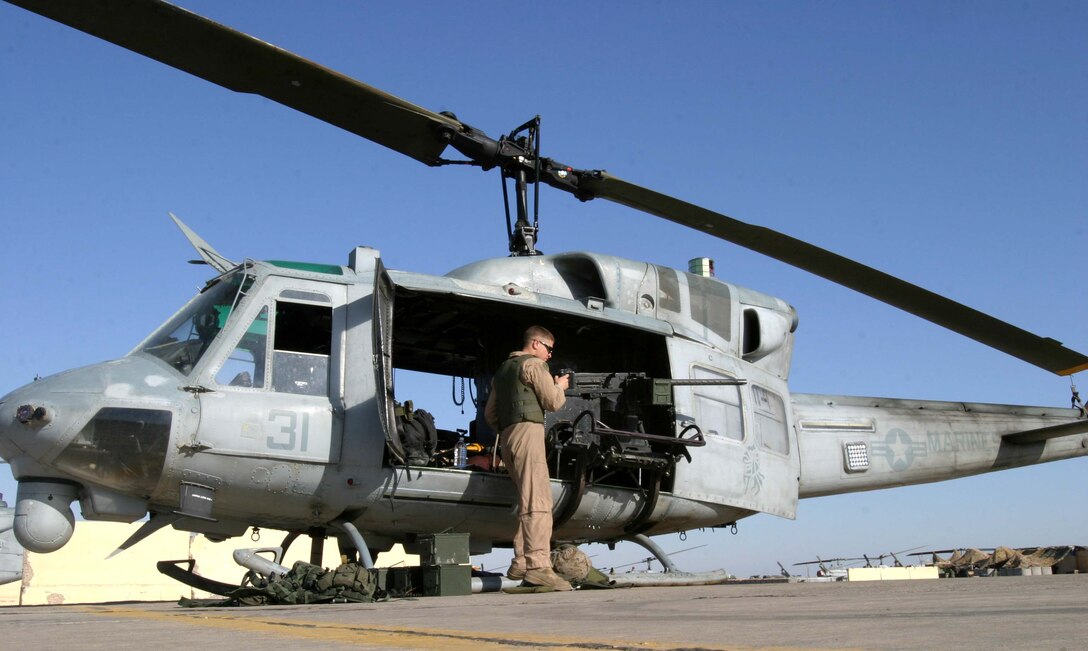 Cpl. Andrew B. Legg, a UH-1N Huey crew chief for HMM-165 (REIN), 15th Marine Expeditionary Unit (Special Operations Capable), prepares a .50 caliber machine gun before a mission. The 15th MEU (SOC) is wrapping up one month of security and stabilization operations in the Greater Baghdad area.