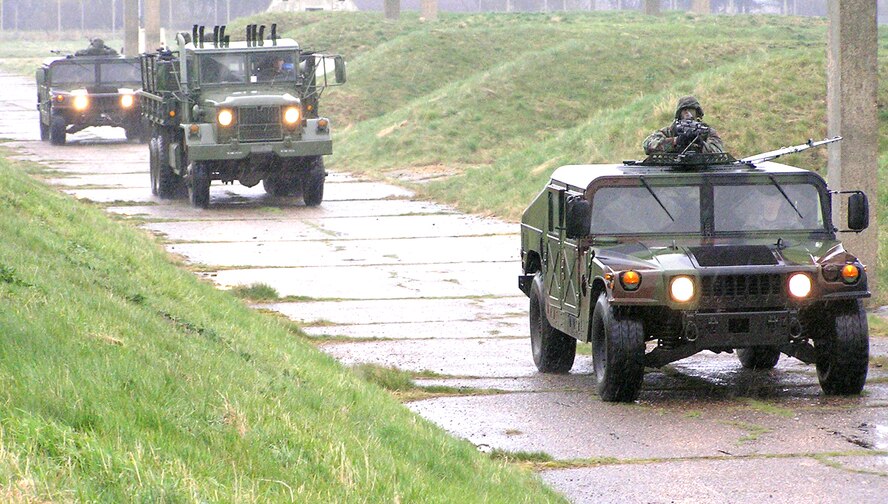 ROYAL AIR FORCE MILDENHALL, England -- Airmen with the 100th Security Forces Squadron form a convoy configuration during combat readiness force training.  They patrolled the area several times before responding to an attack by the "enemy," at which point they left to set up security areas around the convoy.  (U.S. Air Force photo by Karen Abeyasekere)