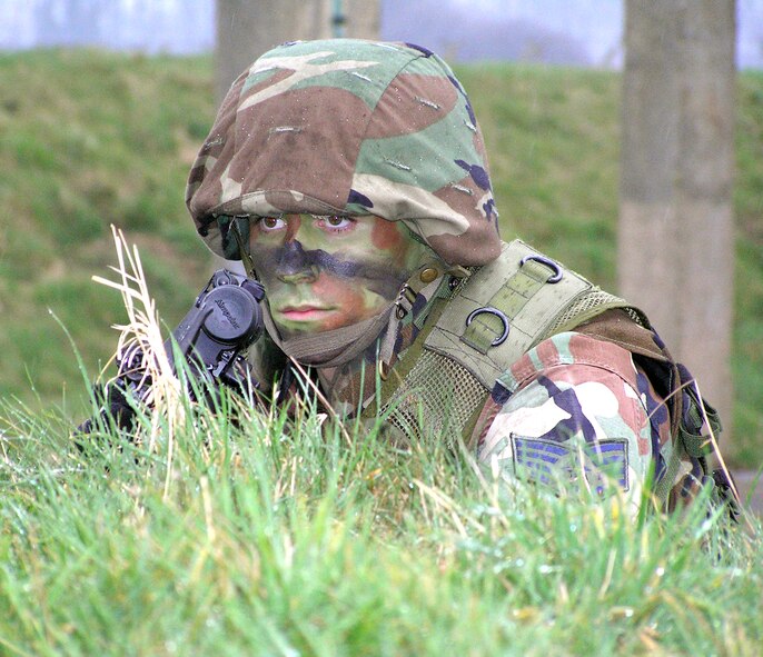ROYAL AIR FORCE MILDENHALL, England -- Staff Sgt. Ryan Cole surveys the area after setting up security around a halted convoy at the training complex here during combat readiness force training.  The sight cap was intentionally left on the weapon to protect the sight from bad weather damage during the weeklong training.  Sergeant Cole is assigned to the 100th Security Forces Squadron.  (U.S. Air Force photo by Karen Abeyasekere)   