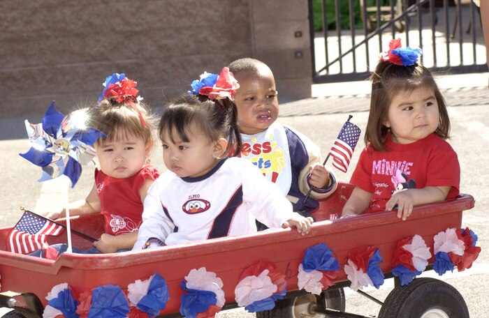 NELLIS AIR FORCE BASE, Nev. -- Children at the child development center here ride in the back of a wagon during the red, white and blue parade April 1 to kick off the Month of the Military Child.  (U.S. Air Force photo by Tech. Sgt. Demetrius Lester) 