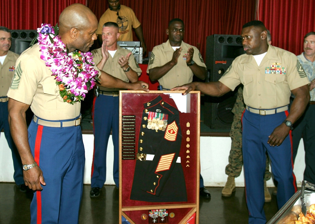 Master Gunnery Sergeant Mike F. Phillip receives his going away plaque from Sergeant Major Juan D. Williams.  The reception was held at the Sunset Lanai after their retirement ceremony, April 8, 2005, on Bordelon Field, Camp H. M. Smith, HI.  (USMC photo by Lance Corporal Angela Hitchcock.)