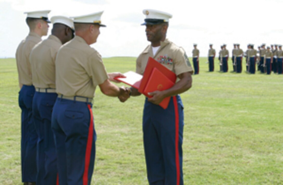 Master Gunnery Sergeant Mike F. Phillip shakes hands with Colonel Micheal Crites, April 8, 2005 at Camp H. M. Smith, HI.  MGYSGT Phillip and Master Sergeant Reggie V. McKenzie shared their retirement ceremonies on Bordelon Field aboard Camp H. M. Smith.  (USMC photo by Lacne Corporal Angela Hitchcock.)