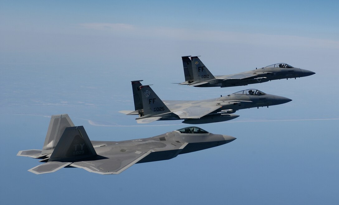 OVER THE ATLANTIC OCEAN -- An F/A-22 Raptor, foreground, flies in formation with two F-15 Eagles en route to a training area off the coast of Virginia on April 5.  The F/A-22 is assigned to the 27th Fighter Squadron and the F-15s are assigned to the 1st Fighter Wing, both at Langley Air Force Base, Va. The Raptor is on loan from Tyndall AFB, Fla. (U.S. Air Force photo by Tech. Sgt. Ben Bloker)