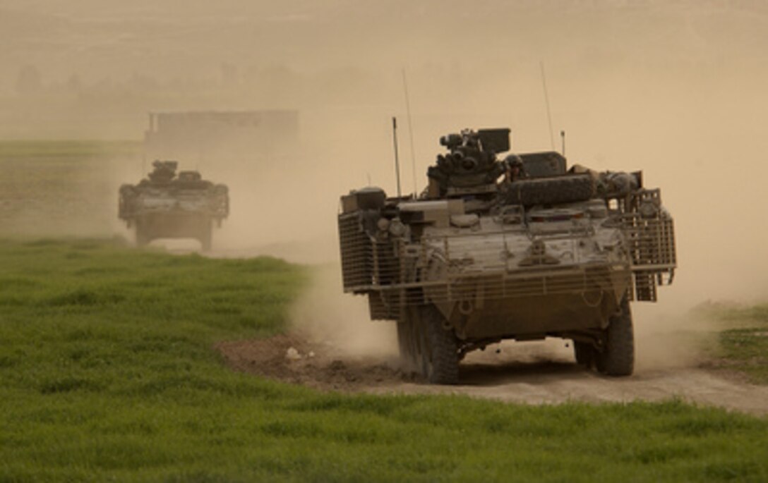 Army Stryker vehicles of the Stryker Brigade Combat Team kick up plumes of dust as they conduct a patrol near Mosul, Iraq, on March 31, 2005. These Strykers are from the 2nd Platoon, Bravo Company, 1st Battalion, 5th Infantry, 25th Infantry Division. 