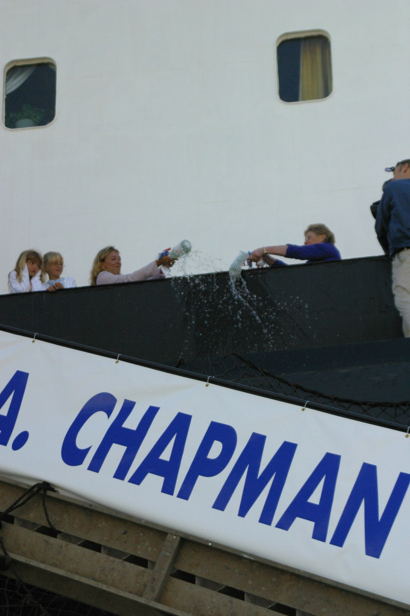 SUNNY POINT, N.C. -- Valerie Chapman (left) and Mickey Handy christen the MV Tech. Sgt. John A. Chapman on the ship’s railing April 8. The women co-sponsored the ceremony. Mrs. Chapman is Sergeant Chapman’s widow, and Mrs. Handy is Gen. John W. Handy’s wife. (U.S. Air Force photo by Lisa Terry McKeown)