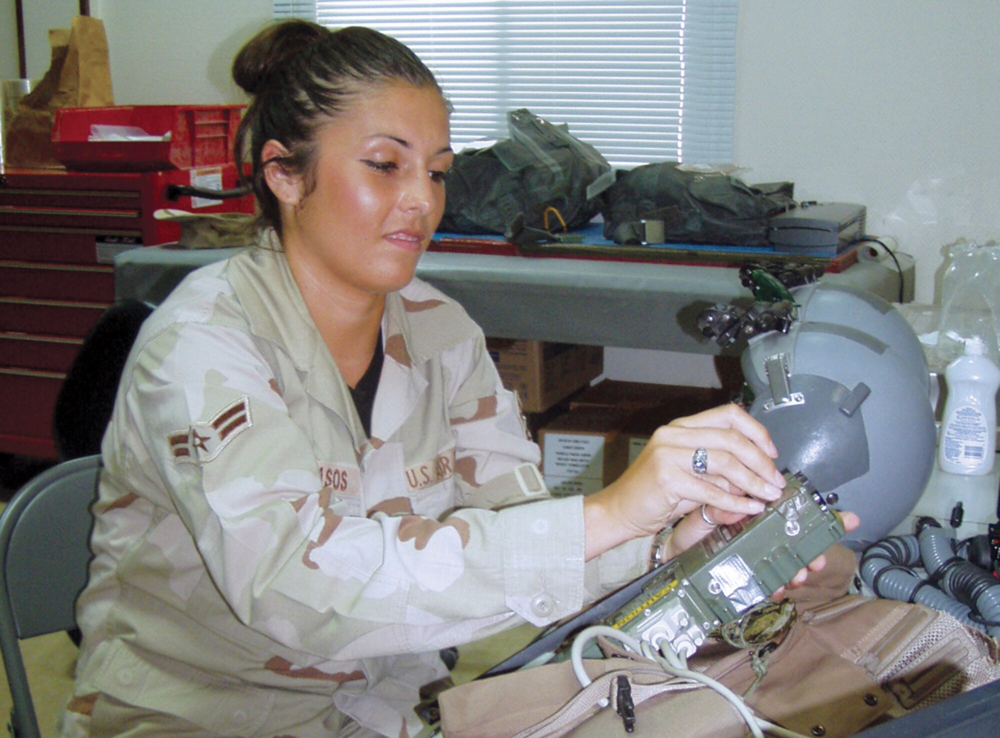 SOUTHWEST ASIA -- Airman 1st Class Shannon Cavasos loads frequencies into radios used to assist downed aircrews who must survive on the ground until search-and-rescue support arrives.  She is a life-support technician with the 494th Expeditionary Fighter Squadron at a forward-deployed location and is from Royal Air Force Lakenheath, England.  (U.S. Air Force photo by Tech. Sgt. Michael Dorsey)