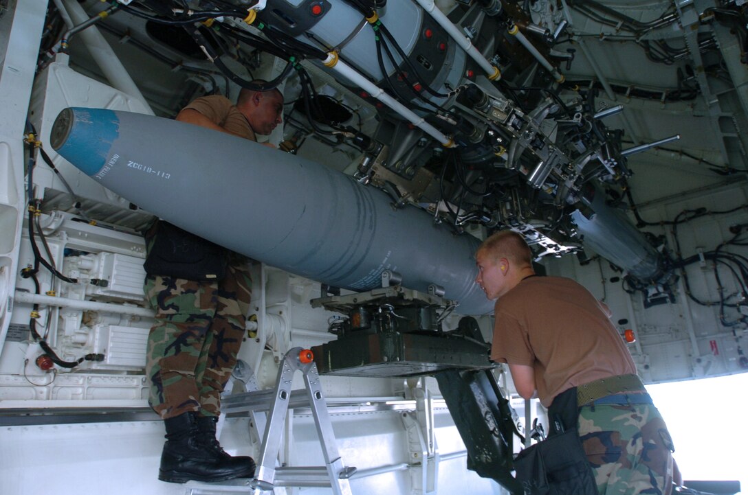 ANDERSEN AIR FORCE BASE, Guam -- Staff Sgt. Michael Taylor (left) and Senior Airman Joseph Nelson load a bomb on a B-2 Spirit bomber here.  They are weapons specialists deployed from the 509th Aircraft Maintenance Squadron at Whiteman Air Force Base, Mo.  (U.S. Air Force photo by Master Sgt. Val Gempis)