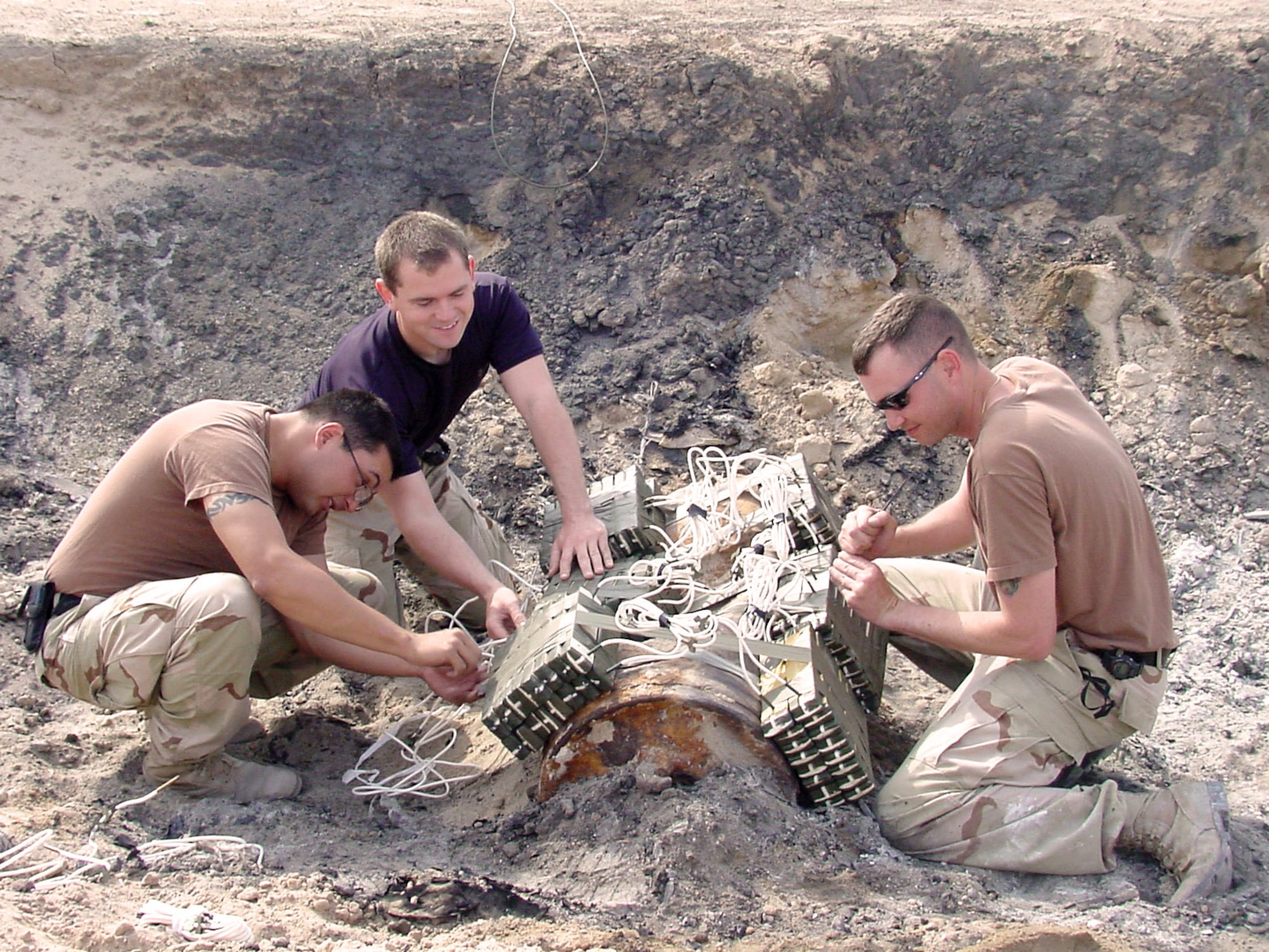 SOUTHWEST ASIA -- Staff Sgts. Jason Wilburn, Joseph Leslie and Brad Ferguson prepare to detonate a Russian-made bomb that was discovered by an Airman at a construction site at a forward-deployed location.  They are assigned to the 386th Expeditionary Civil Engineer Squadron's explosive ordnance flight.  (U.S. Air Force photo)