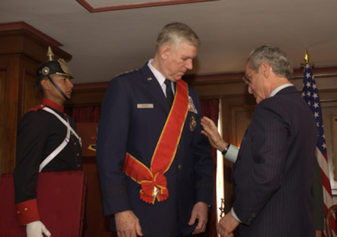 Colombian Minister of Defense Jorge Alberto Uribe Echevarria presents the Military Order of Merit, Great Cross to Chairman of the Joint Chiefs of Staff Gen. Richard Myers, U.S. Air Force, in a ceremony in Bogotá, Colombia, on April 11, 2005. Myers is in Colombia to meet with the military and civilian leadership to further military-to-military relations. 