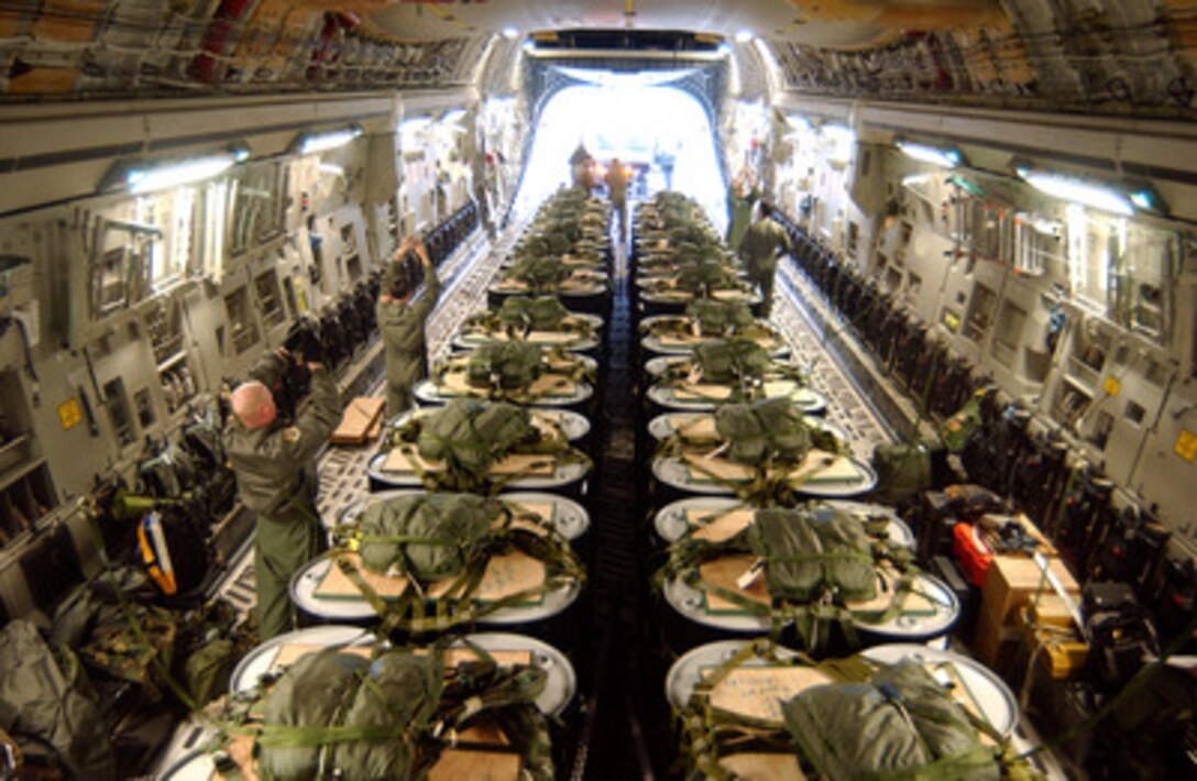 The crew of an Air Force C-17 Globemaster III loads pallets of 55-gallon drums containing fuel at McChord Air Force Base, Wash., on April 12, 2005. Over 10,000 gallons of fuel will be airdropped near the North Pole to aid the National Science Foundation scientists working there. This will be the first North Pole airdrop for a C-17 Globemaster. 