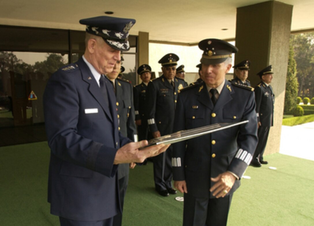 Chairman of the Joint Chiefs of Staff Gen. Richard Myers, U.S. Air Force, admires a plaque given to him by Mexican Secretary of National Defense Gen. Gerardo Vega at the military parade grounds in Mexico City, Mexico, on April 12, 2005. Myers is meeting with military and civilian leadership in Mexico to further military-to-military relations. 