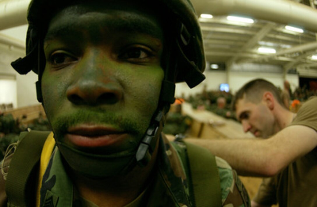 An Army paratrooper from the 82nd Airborne Division and his equipment are prepared for a night parachute jump onto Fort Bragg, N.C., during Joint Forcible Entry Exercise on April 7, 2005. The exercise is a U.S. Army and Air Force airdrop exercise designed to properly execute large-scale heavy equipment and troop movement. 