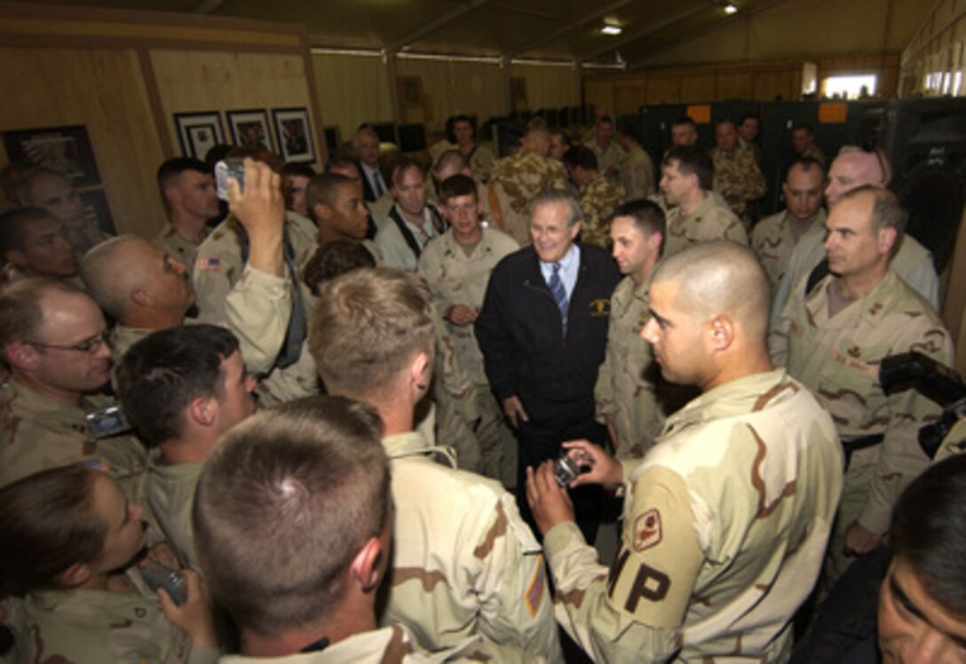 Secretary of Defense Donald H. Rumsfeld is surrounded by troops as he poses with them for photos after a town hall meeting with U.S. and coalition forces in Kandahar, Afghanistan, on April 13, 2005. Rumsfeld is in Afghanistan to visit with U.S. and coalition forces and to meet with key government officials. 