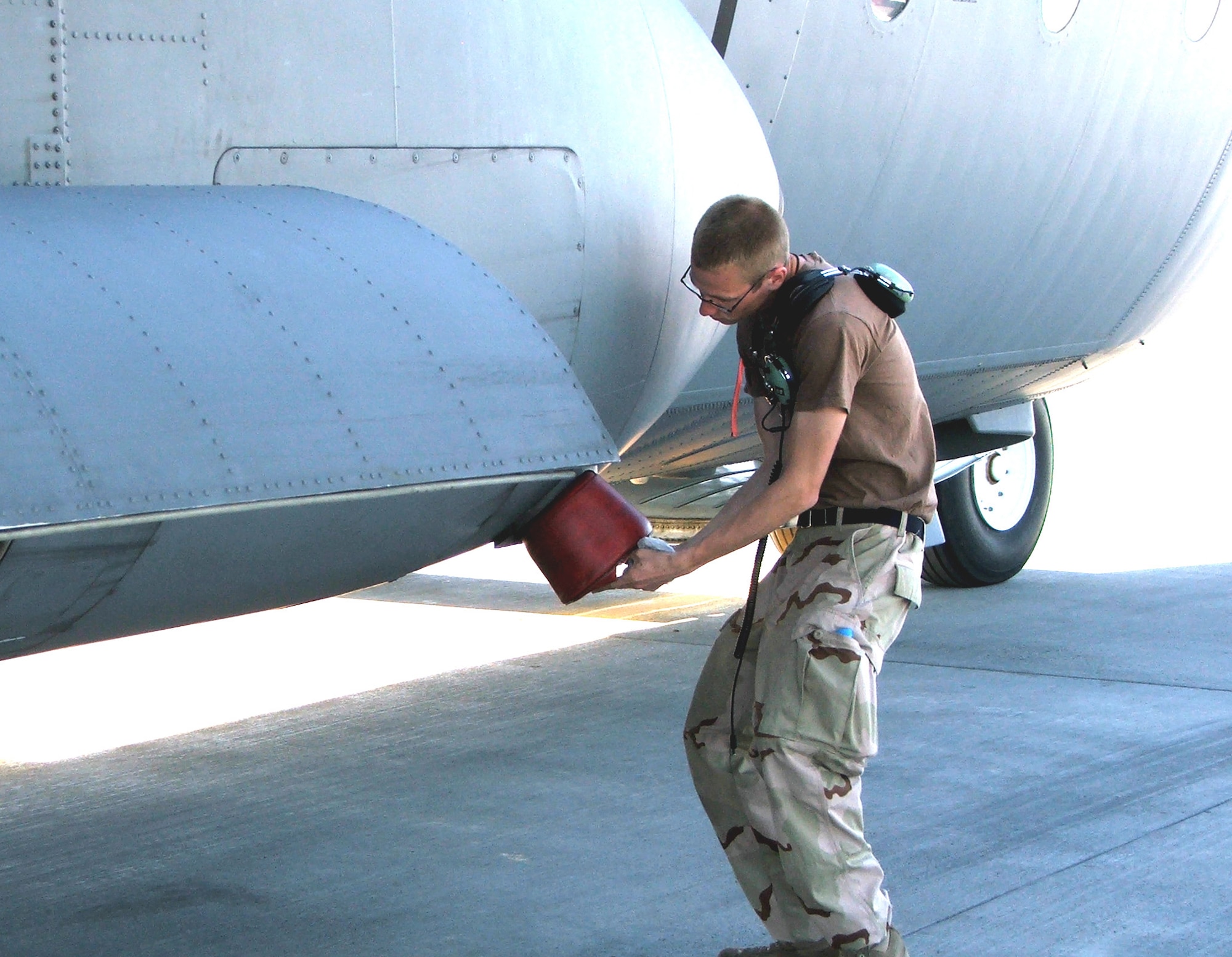 KARSHI-KHANABAD AIR BASE, Uzbekistan -- Senior Airman Christopher Green puts a plug into a C-130 Hercules exhaust port here after the recovery of a C-130 that returned from a mission April 14.  He is a C-130 crew chief deployed from Elmendorf Air Force Base, Alaska.  (U.S. Air Force photo by Tech. Sgt. Scott T. Sturkol)