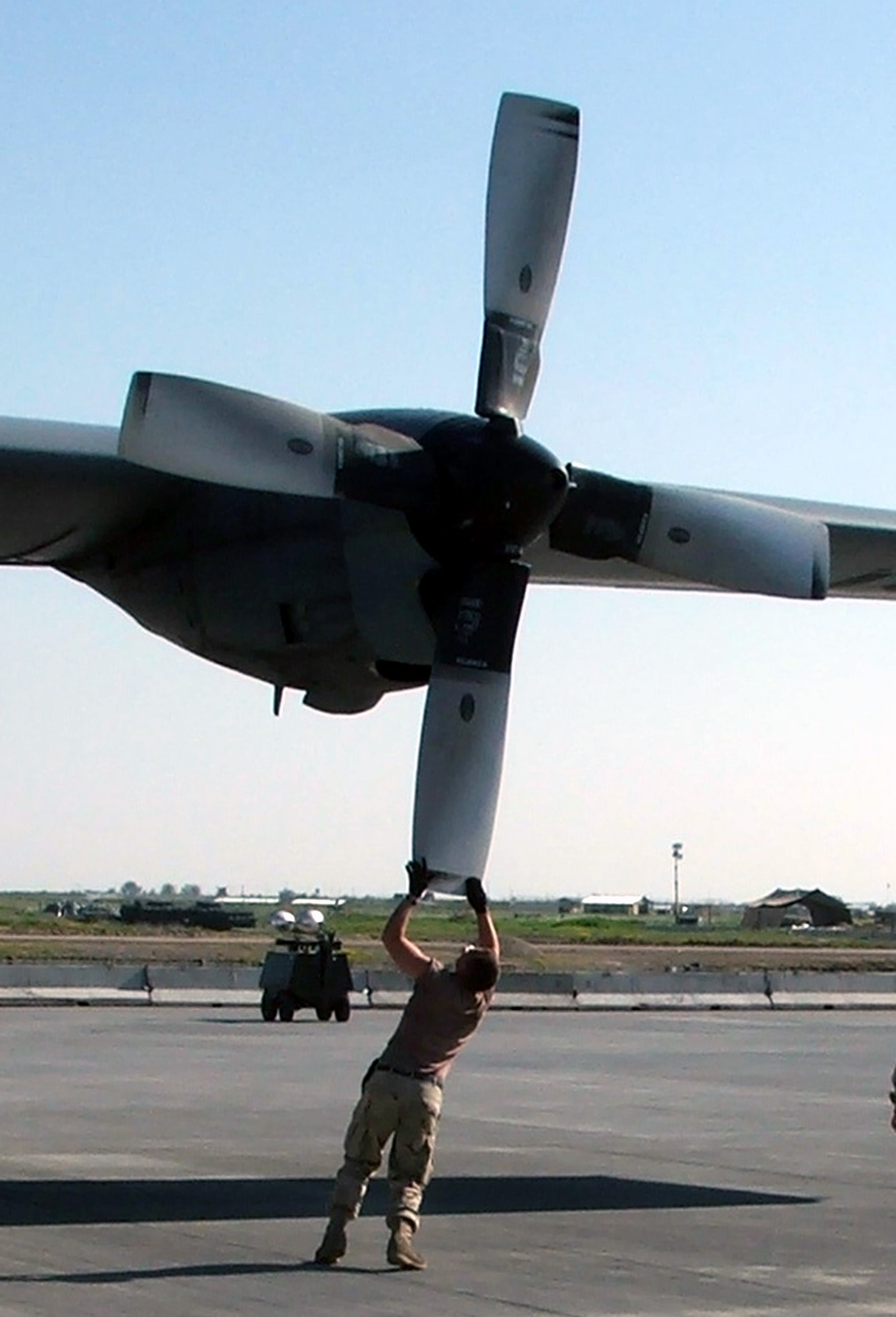 KARSHI-KHANABAD AIR BASE, Uzbekistan -- Airman 1st Class David Solis pushes a C-130 Hercules propeller into place during an aircraft recovery here April 14.  He is a C-130 crew chief with the 774th Expeditonary Airlift Squadron and is deployed from Elmendorf Air Force Base, Alaska.  (U.S. Air Force photo by Tech. Sgt. Scott T. Sturkol)