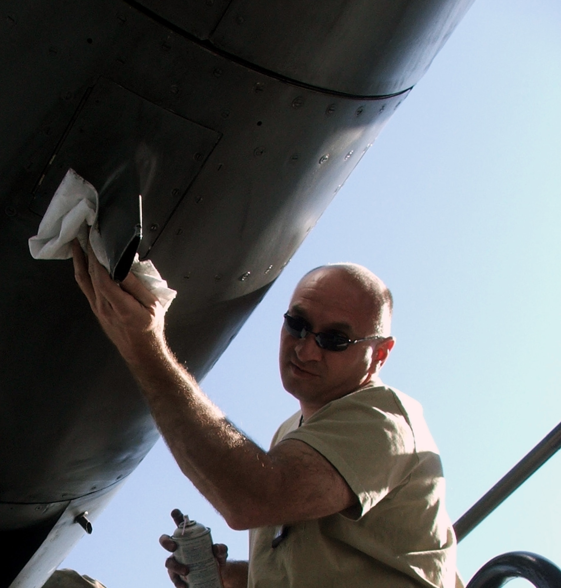 KARSHI-KHANABAD AIR BASE, Uzbekistan -- Master Sgt. Joseph Ohmes wipes down an engine compartment of a C-130 Hercules after reassembling the compartment April 14.  He is a C-130 engine mechanic with the 774th Expeditionary Airlift Squadron and is deployed from the Missouri Air National Guard at St. Joseph.  (U.S. Air Force photo by Tech. Sgt. Scott T. Sturkol)