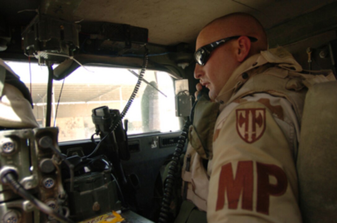 Army Military Policeman Staff Sgt. Donald Wagers radios in his convoy's departure information before delivering ammunition to three local Iraqi Police stations in Najaf, Iraq, on April 2, 2005. Wagers is attached to the 940th Military Police Unit and is part of the 155th Brigade Combat Team forward deployed to Camp Hotel in central Iraq. 