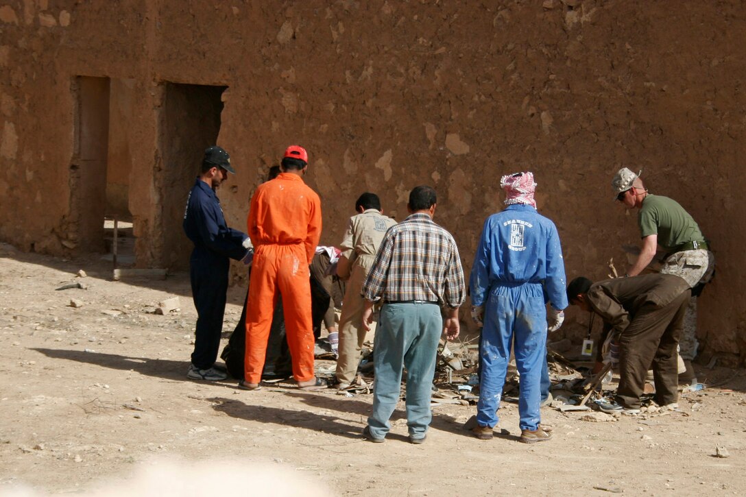 AL ASAD, Iraq -- Iraqi workers here separate trash April 16 during the clean up of a legendary site.  The Iraqis, who work at the police academy, joined the efforts of Marines, sailors and American civilians in restoring a military cemetery, an oasis and the ruins of a building where Abraham, who plays a significant role in the history of three major faiths, is rumored to have spent one night during one of his travels through this area.