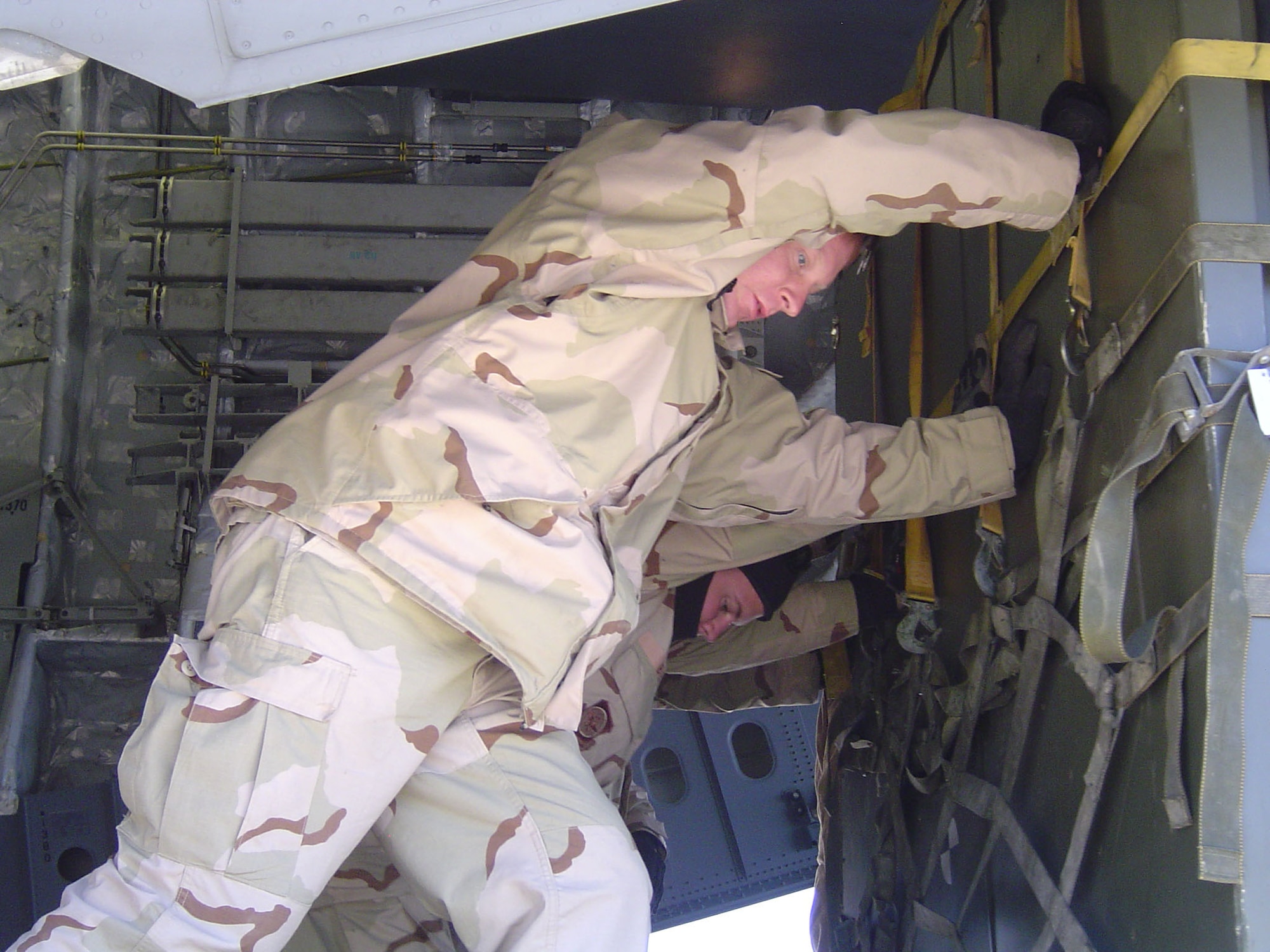 HERAT, Afghanistan - (From left) Staff Sgts. Thomas Pollard and Michael Cassell unload a C-17 Globemaster III filled with supplies flown here for the Italian troops, who will assume leadership over the international security assistance force.  Sergeants Pollard and Cassell are with the tanker airlift control element's aerial port.  (U.S. Air Force photo by Capt. Catie Hague)