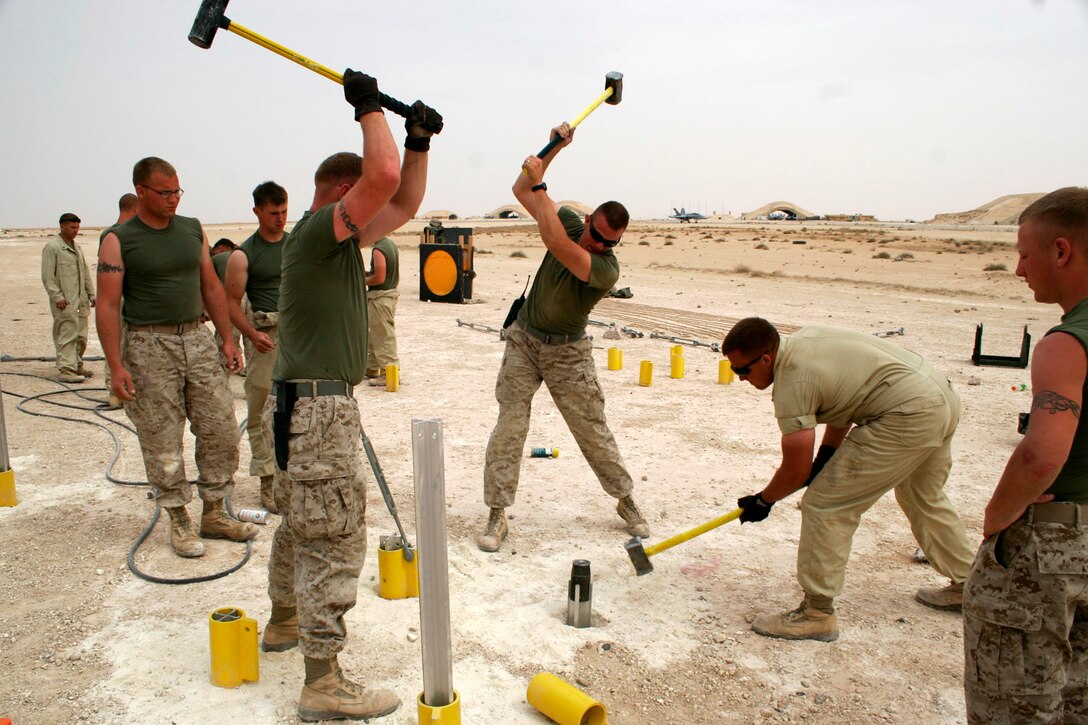 AL ASAD, Iraq ? Aircraft recovery specialists from Marine Wing Support Squadron 271 hammer down cruciform stakes while relocating an expeditionary arresting gear trailer April 20.  The stakes serve as anchoring supports for the gear during aircraft arrestments.
