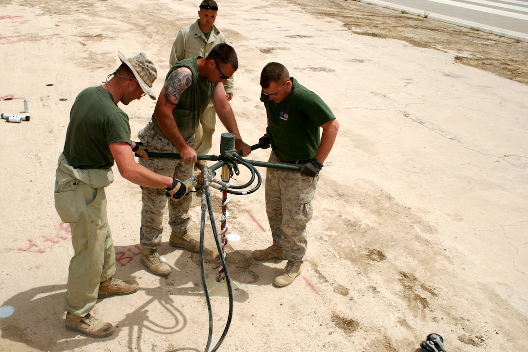 AL ASAD, Iraq ? Corporals Daryl R. Chilton, Robert E. Rowe and Traeh E. Whittington, aircraft recovery specialists assigned to Marine Wing Support Squadron 271, pre-drill holes for cruciform stakes while relocating an expeditionary arresting gear trailer April 20.  Chilton, from Hopkinsville, Ky.; Rowe, from Industry, Pa.; and Whittington, from Mesquite, Texas, work in the recovery shop of the squadron?s expeditionary airfield division.