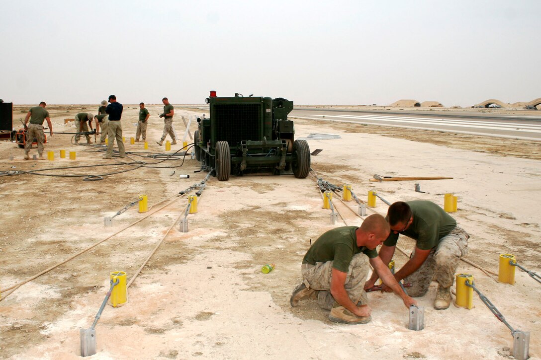 AL ASAD, Iraq ? Lance Cpl. James O. Connolly and Cpl. Robert E. Rowe, aircraft recovery specialists, tighten up a turnbuckle while setting up anchor supports for an expeditionary arresting gear trailer April 20.  Connolly, from Westchester, N.Y., and Rowe, from Industry, Pa., are assigned to the expeditionary airfield division of Marine Wing Support Squadron 271.