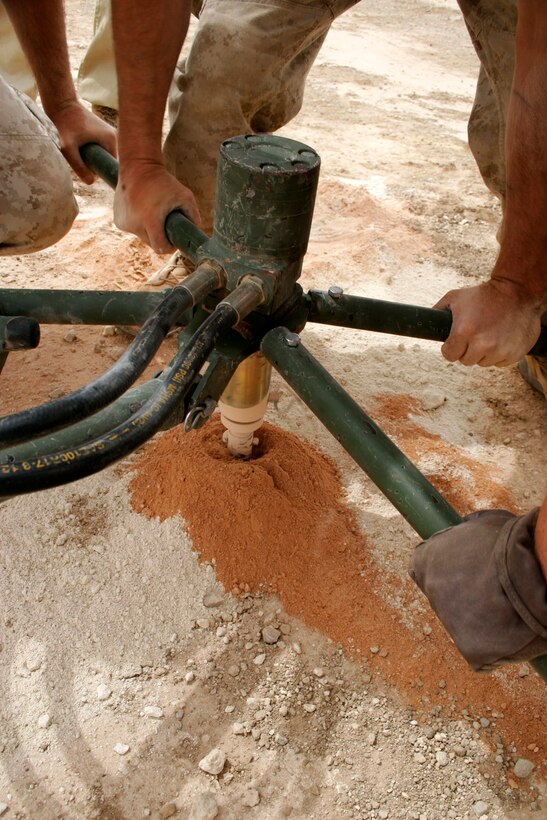 AL ASAD, Iraq ? Lance Cpl. James O. Connolly and Cpls. Robert E. Rowe and Traeh E. Whittington, aircraft recovery specialists assigned to Marine Wing Support Squadron 271, pre-drill a hole for cruciform stake while relocating an expeditionary arresting gear trailer April 20.  Connolly, Westchester, N.Y.; Rowe, from Industry, Pa.; and Whittington, from Mesquite, Texas, work in the recovery shop of the squadron?s expeditionary airfield division.