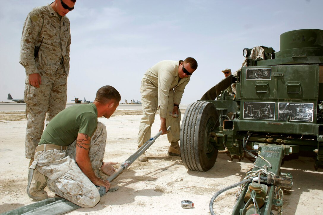 AL ASAD, Iraq ? Sergeant James S. Happley and Lance Cpl. Dustin J. Schneider, aircraft recovery specialists assigned to Marine Wing Support Squadron 271, prepare a turnbuckle while setting up the tool to mark where the cruciform stakes will go.  The stakes serve as anchoring supports for the expeditionary arresting gear trailer during aircraft arrestments.