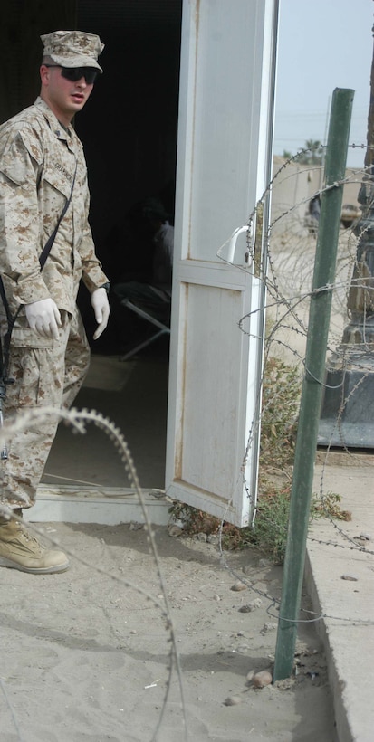 CAMP HURRICANE POINT, Ar Ramadi, Iraq (April 29, 2005) -Corporal Dan L. Grabinski, legal administrative clerk with Headquarters and Service Company, 1st Battalion 5th Marine Regiment, stands outside the camp's detainee facility as he fills his secondary billet as the day non commissioned officer in-charge. The 21-year-old from Schiller Park, Ill., processes expected insurgents his fellow infantry battalion leathernecks snatched up out of the city while conducting security and stabilization missions. With help from three other Marines, Grabinski runs the detainees through the biometric automative tools system, which helps them distinguish members of the insurgency from innocent Iraqi civilians. Detainees found guilty of committing terrorist acts are sent to the Abu Ghraib Prison. Photo by Cpl. Tom Sloan
