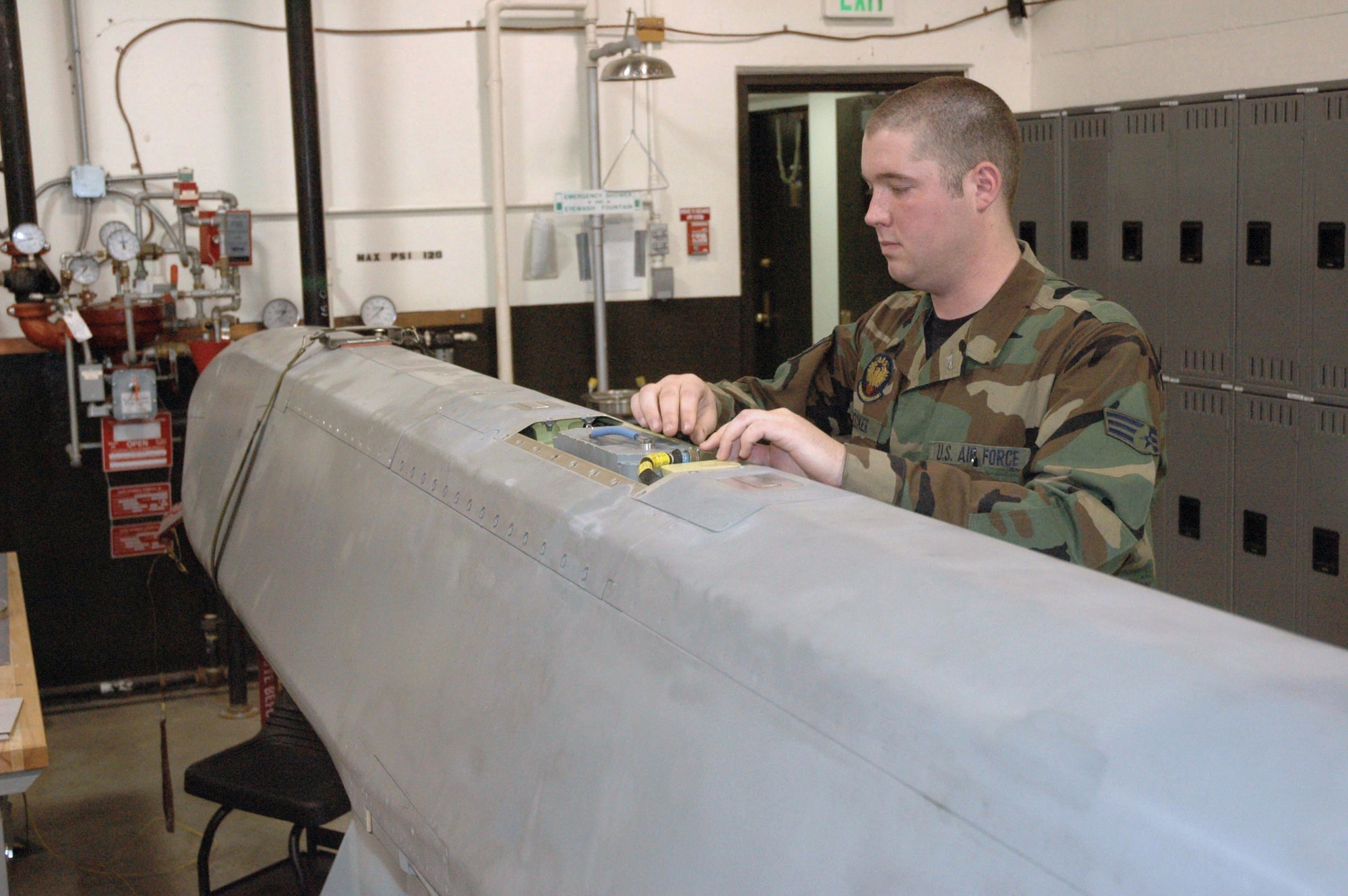 MINOT AIR FORCE BASE, N.D. -- Senior Airman Justin Decker examines an air-to-ground missile in the weapons storage area here.  The B-52 Stratofortress can hold up to 20 of these missiles.  He is a missile and space systems electronic maintainer with the 5th Munitions Squadron.  (U.S. Air Force photo by Airman 1st Class Ross Tweten)