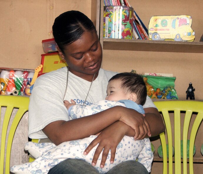 QITAB, Uzbekistan -- Staff Sgt. Lakeitha Luster holds an Uzbek baby during a humanitarian assistance visit to a baby orphanage here.  Airmen, Soldiers and civilians from nearby Karshi-Khanabad Air Base visited the orphanage and handed out handmade baby quilts, baby formula, diapers, clothes and toys.  Sergeant Luster is assigned to the 416th Expeditionary Mission Support Squadron's civil engineer flight and is deployed from Randolph Air Force Base, Texas.  (U.S. Air Force photo by Tech. Sgt. Scott T. Sturkol)