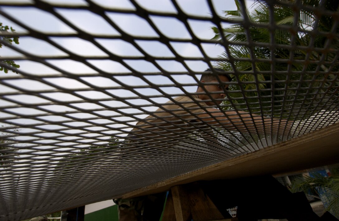 SAN VICENTE, El Salvador -- Airman 1st Class Emmanuel Solois cleans expanded metal at a clinic-building project here April 13. The project is one of the New Horizons exercise projects that will provide two new schools and three clinics in areas that were hit by earthquakes. Airman Solois is assigned to the 28th Civil Engineer Squadron at Ellsworth Air Force Base, S.D. (U.S. Air Force photo by Tech. Sgt. John M. Foster) 