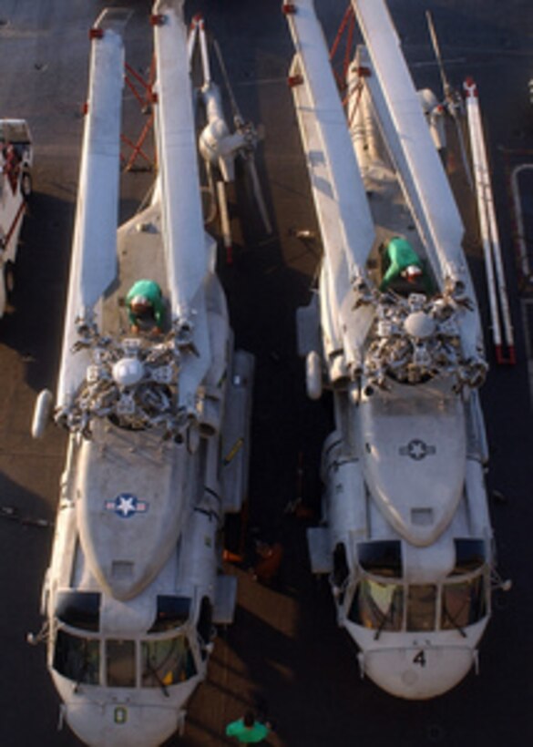 Sailors assigned to Helicopter Anti-Submarine Squadron 7 perform maintenance on the main rotors of two SH-60F Seahawk helicopters on the flight deck of USS Harry S. Truman (CVN 75) as the ship operates in the Persian Gulf on March 22, 2005. The Truman Strike Group and Carrier Air Wing 3 are conducting close air support, intelligence, surveillance, and reconnaissance missions over Iraq. 