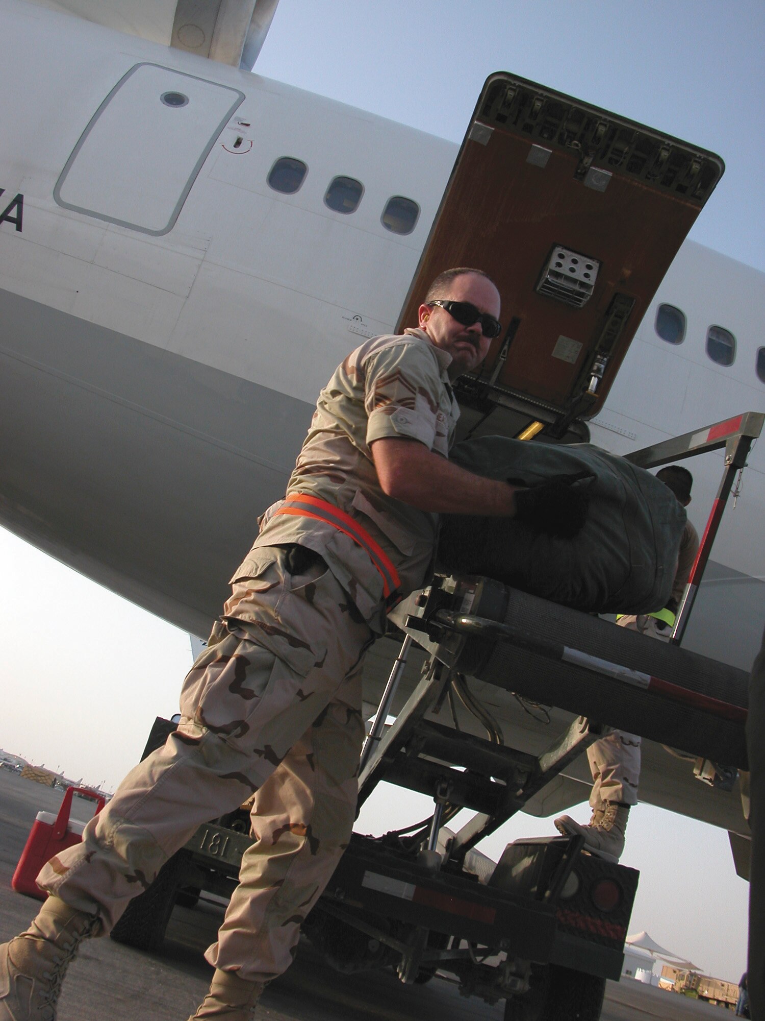 SOUTHWEST ASIA -- Senior Master Sgt. John Heasley helps unload luggage from a rotator flight recently.  Airmen from the 8th Expeditionary Air Mobility Squadron, along with the 379th Expeditionary Logistics Readiness Squadron's reception control center and the 379th Expeditionary Mission Support Group's personnel support for contingency operations office, are responsible for processing servicemembers in and out of U.S. Central Command's area of responsibility.  Sergeant Heasley is the superintendent for the 8th EAMS.  (U.S. Air Force photo by Senior Airman Karah Manning)
