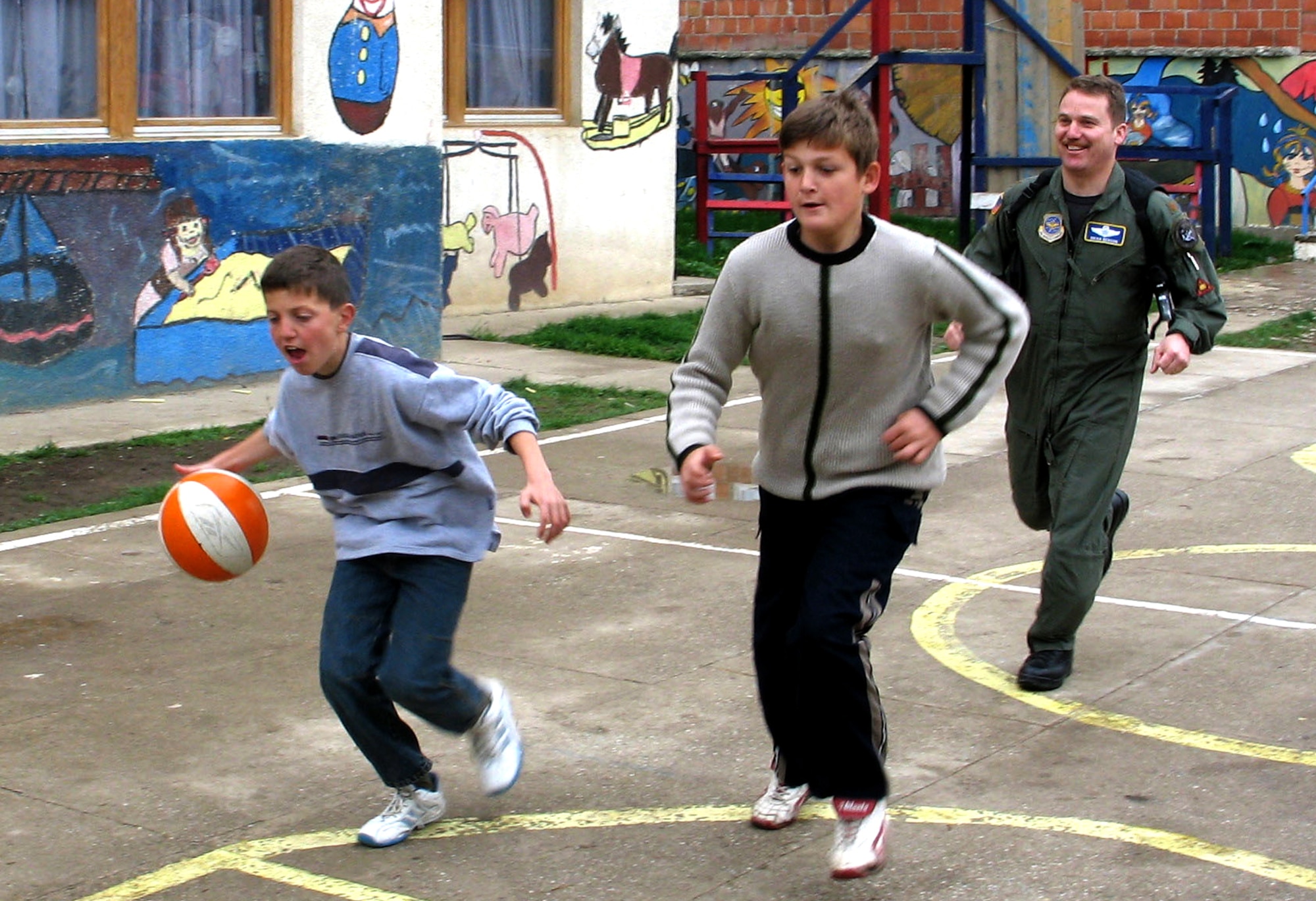 PRISTINA, Serbia and Montenegro -- Maj. Brian Benson plays basketball with children during a recent visit to the Pristina Mother and Child Center here.  He is assigned to Kosovo Force headquarters at NATO Base Film City.  (U.S. Air Force photo by Master Sgt. Lee Roberts)