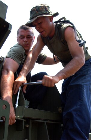 Lance Cpl. Robert Cotterell (left), Marine Wing Support Squadron 171 expeditionary airfield services crewman, holds a wrench in place while Lance Cpl. Uverne Peralta (right), MWSS-171  expeditionary airfield services crewman, turns a socket while assembling eqipment in preperation for Cobra Gold 2005.
