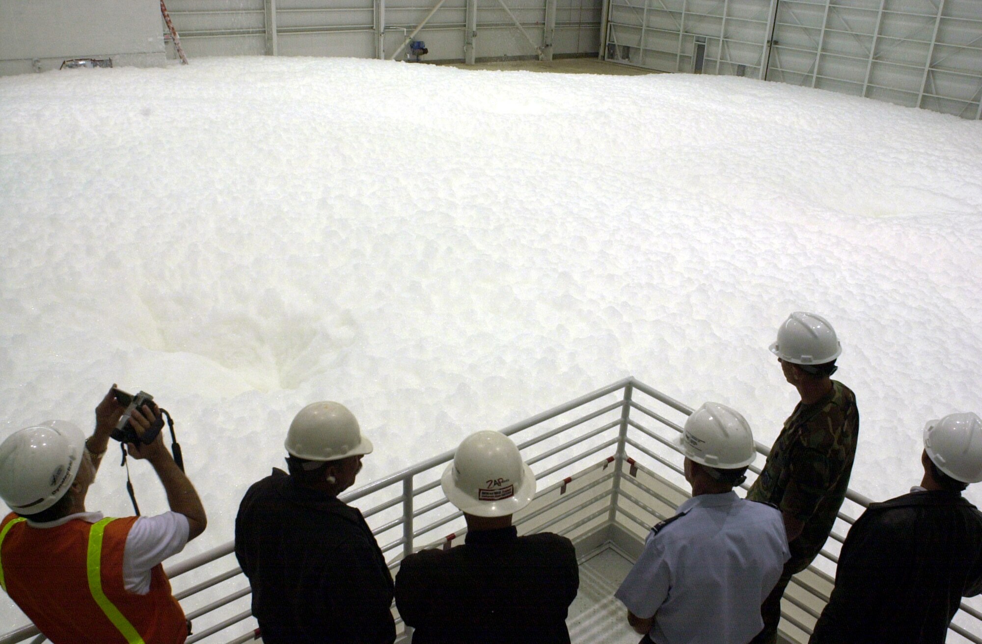 MARCH AIR RESERVE BASE, Calif. -- People from the 452nd Air Mobility Wing's civil engineer squadron and fire department here observe the final fire sprinkler foam test in a new state-of-the-art hangar built to house the wing's C-17 Globemaster IIIs, which are scheduled to begin arriving Aug. 9.  As one of many safety features designed for the hangar, foam is dispensed from nine generators that can smother flames in less than one minute.  (U.S. Air Force photo by Erickson J. Barnes)