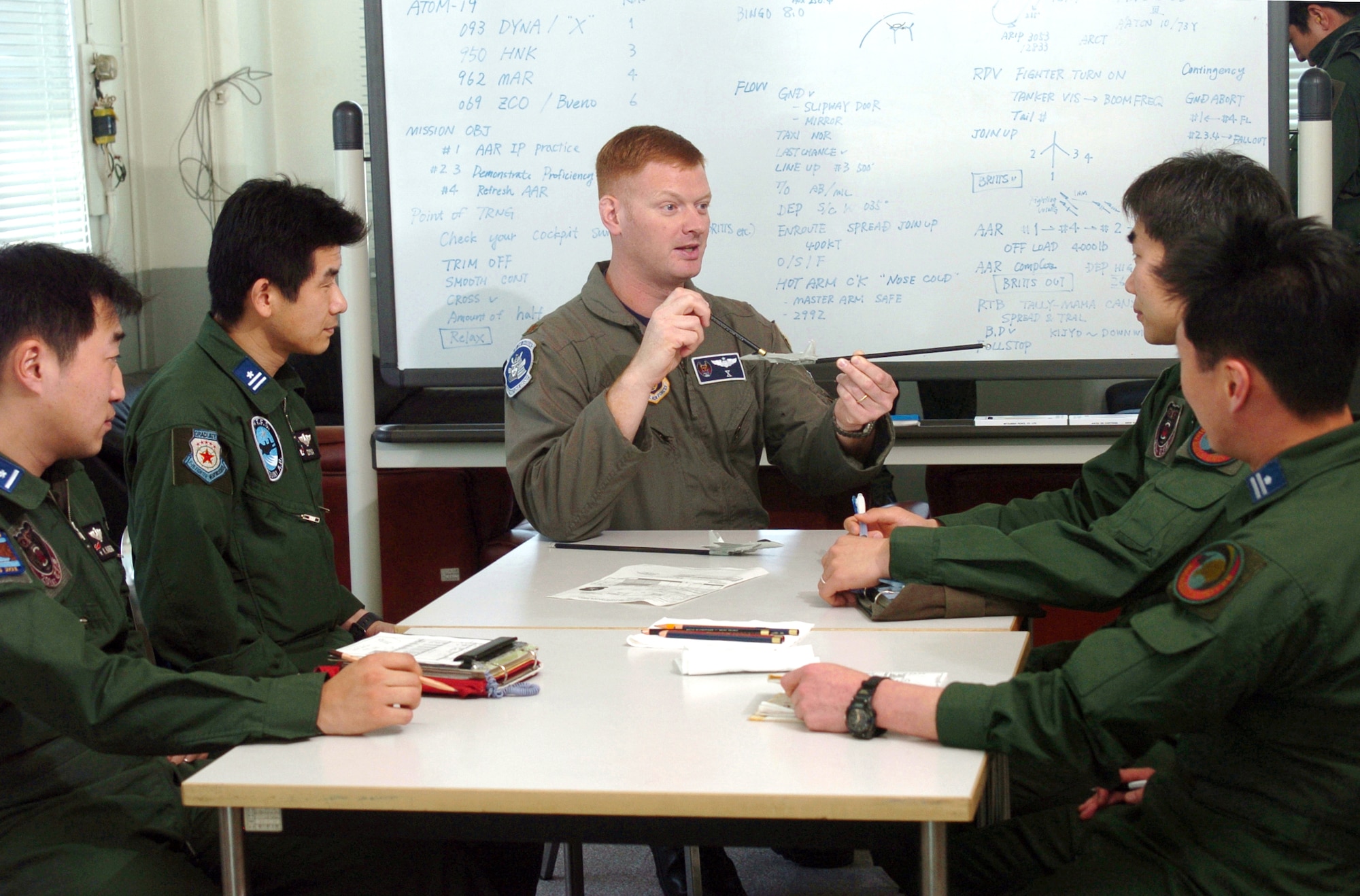 NYUTABARU AIR BASE, Japan -- Maj. Malcolm Kemeny discusses tactics during a preflight mission brief with Japanese airmen during hands-on air-to-air refueling training here.  Japanese F-15 Eagle pilots, under the watchful eye of U.S. Airmen, are getting trained to qualify in aerial refueling.  Major Kemeny is an F-15 pilot from the 18th Operations Group at Kadena Air Base, Japan.  (U.S. Air Force photo by Master Sgt. Val Gempis)