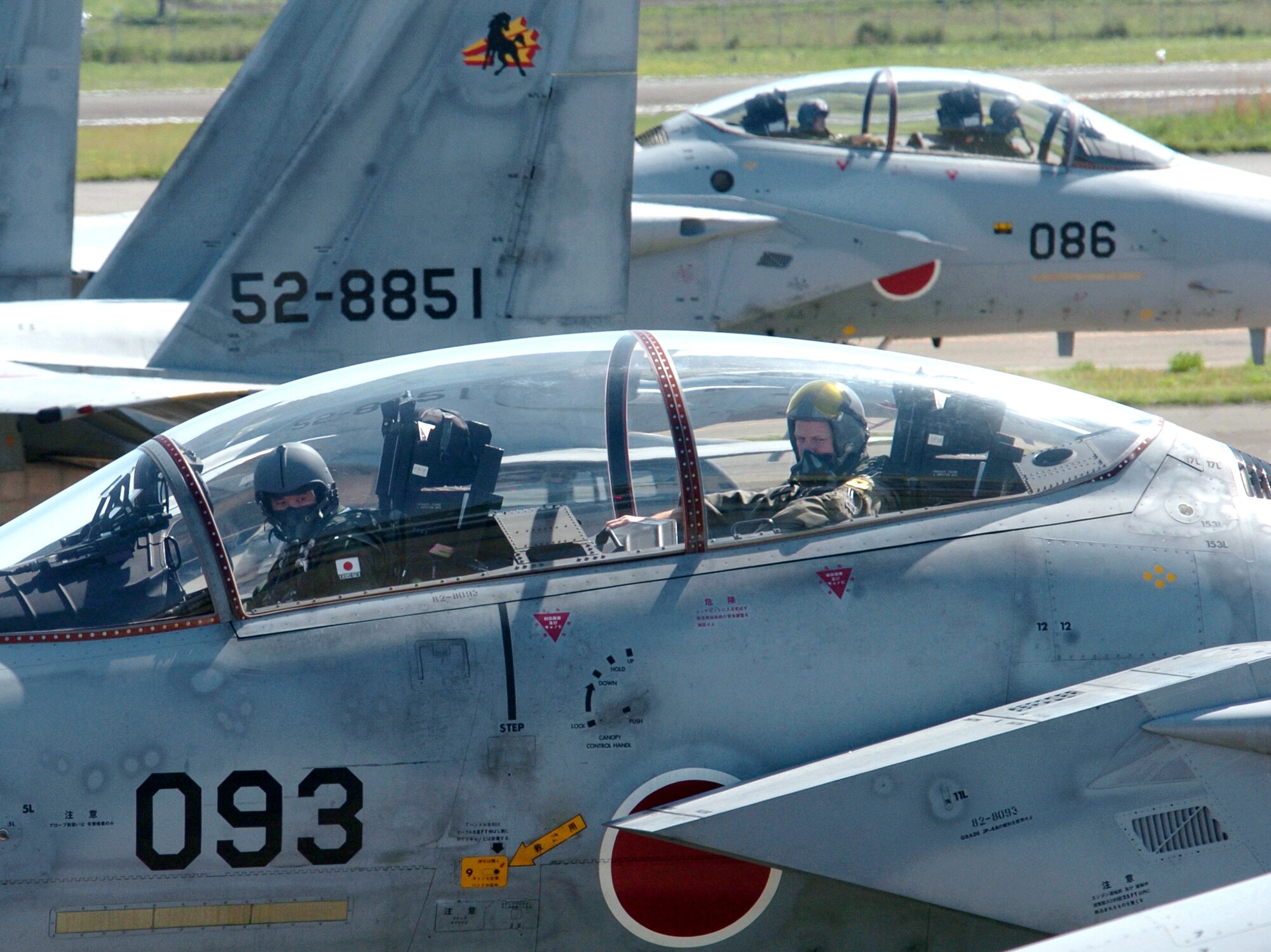NYUTABARU AIR BASE, Japan -- Japanese Maj. Yasuhiro Sudo (left) and Maj. Malcolm Kenemy prepare to take off for an afternoon mission during hands-on air-to-air refueling training here.  Japanese F-15 Eagle pilots, under the watchful eye of U.S. Airmen, are getting trained to qualify in aerial refueling.  Major Kemeny is an F-15 pilot from the 18th Operations Group at Kadena Air Base, Japan.  (U.S. Air Force photo by Master Sgt. Val Gempis)

