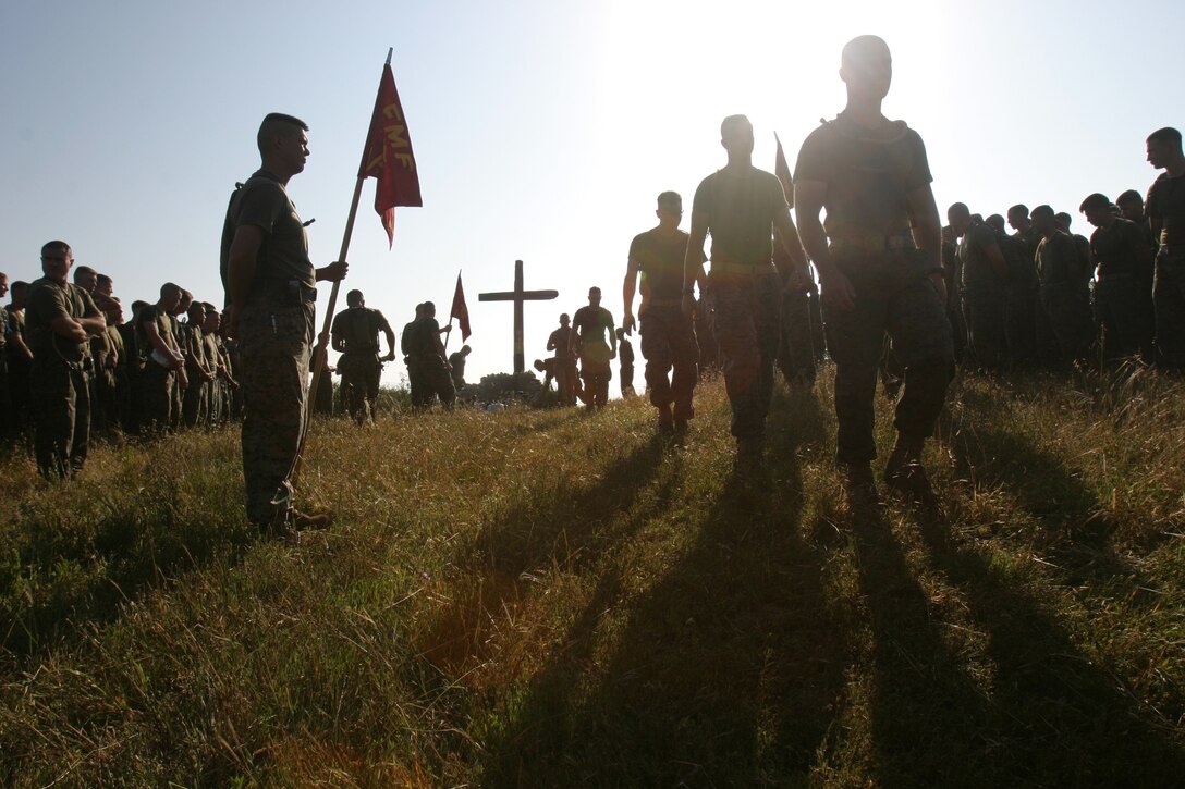 Marines from 1st Battalion, 4th Marine Regiment, place white stones at the base of a memorial site for Marines from 1st Marines that died during Operation Iraqi Freedom I and II outside of Camp Horno, April 26. Every Marine that hikes up San Onofre Mountain to the memorial carries a white stone to place at the memorial's base.