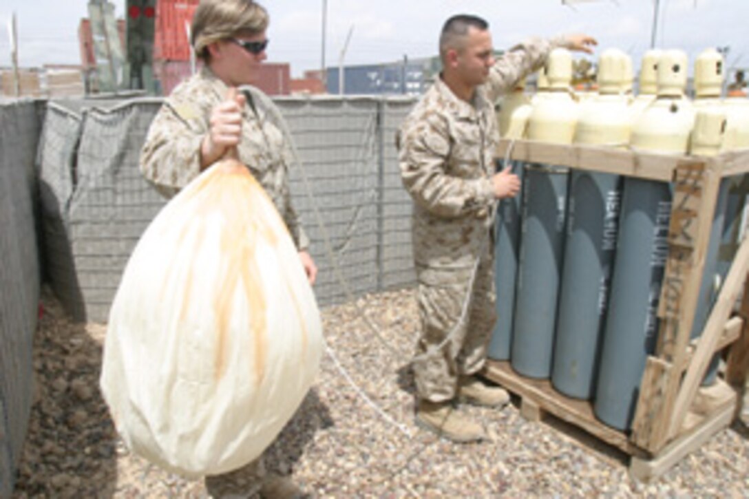As meteorology and oceanography Marines, Cpl. Victor Rodriguez, a  Chicago native, and Cpl. Michelle L. Gottschalk, Island Lake, Ill. native, work together to get accurate and timely weather information out to Camp Fallujah.  Attached with G-2, II Marine Expeditionary Force, Headquarters Group, II MEF (FWD), the Marines know their job is an important part of completing the mission in Iraq.