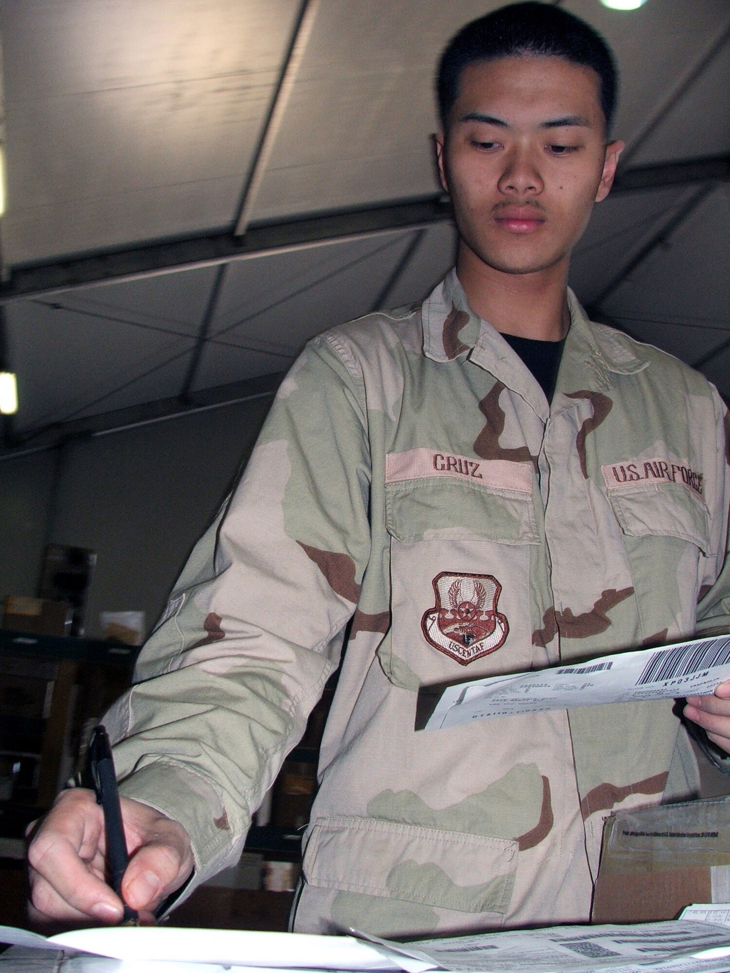KARSHI-KHANABAD AIR BASE, Uzbekistan -- Senior Airman Aaron Cruz checks in cargo in the supply warehouse here April 26.  He is assigned to the 416th Expeditionary Mission Support Squadron's supply section and is deployed from Grand Forks Air Force Base, N.D.  (U.S. Air Force photo by Tech. Sgt. Scott T. Sturkol)