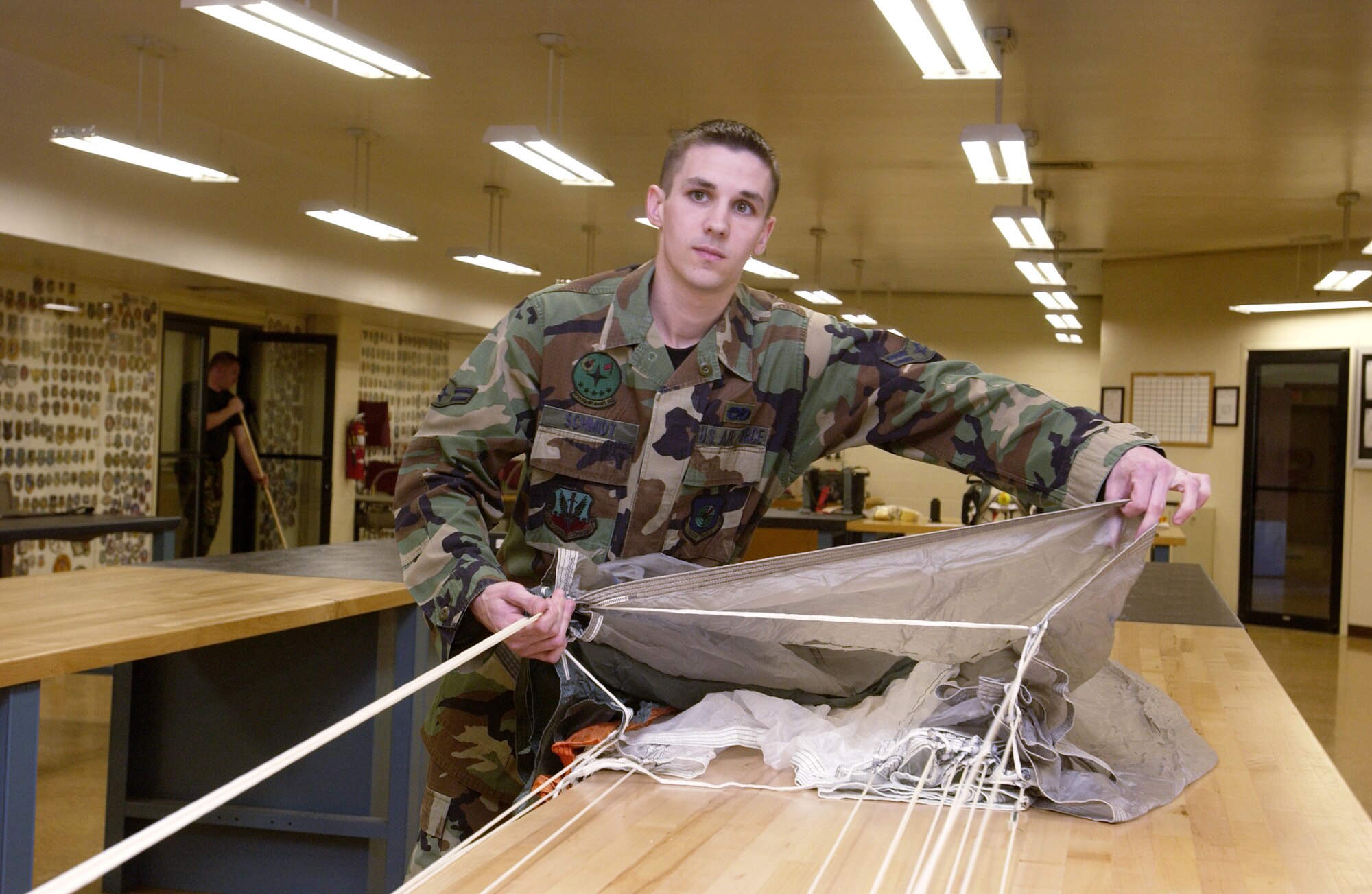 NELLIS AIR FORCE BASE, Nev. -- Airman 1st Class John Schmidt inspects a parachute.  He and other Airmen in the 57th Equipment Maintenance Squadron's survival equipment flight packed the parachutes for pilots involved in three aircraft accidents here within six months, helping to save their lives (U.S. Air Force photo by Tech. Sgt. Demetrius Lester)                  