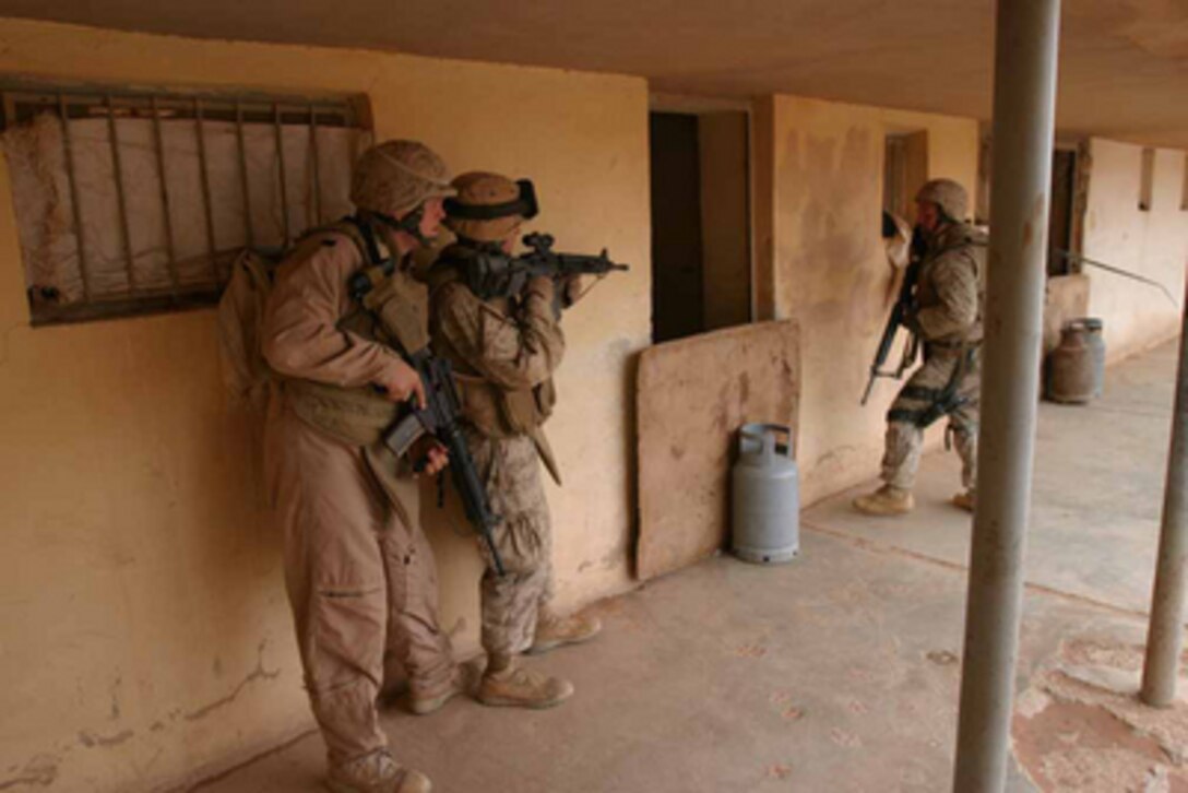 U.S. Marines from the 2nd Light Armored Reconnaissance Battalion stack in formation for an assault on a building in Korean Village, Iraq, on April 24, 2005. The building is believed to be a site where improvised explosive devices or IEDs are being constructed for use by insurgents against coalition forces. The sweep for IEDs is part of security and stabilization operations in the Al Anbar province of Iraq. 
