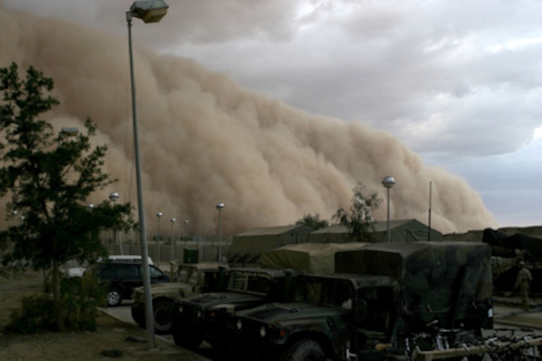 A massive sand storm cloud is close to enveloping a military camp as it rolls over Al Asad, Iraq, just before nightfall on April 27, 2005. 