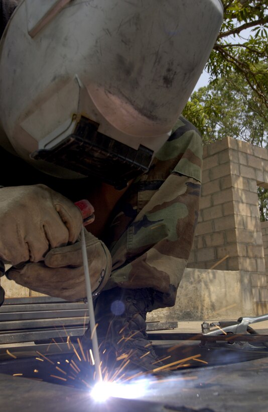 SAN VICENTE, EL Salvador -- Airman 1st Class Christopher McDonald welds roof trusses at a clinic here April 21. The clinic is one of the New Horizons exercise projects that will build two new schools and three clinics in areas that were hit by earthquakes. Airman McDonald is assigned to the 28th Civil Engineer Squadron at Ellsworth Air Force Base, S.D. (U.S. Air Force photo by Tech. Sgt. John M. Foster)