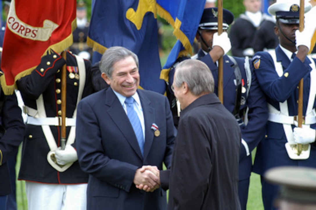 Deputy Secretary of Defense Paul Wolfowitz (left) is congratulated by Secretary of Defense Donald H. Rumsfeld after he presented Wolfowitz with the Department of Defense Medal for Distinguished Public Service during his farewell ceremony on the Pentagon River Parade Field on April 29, 2005. Wolfowitz is leaving the Defense Department to become president of the World Bank. 