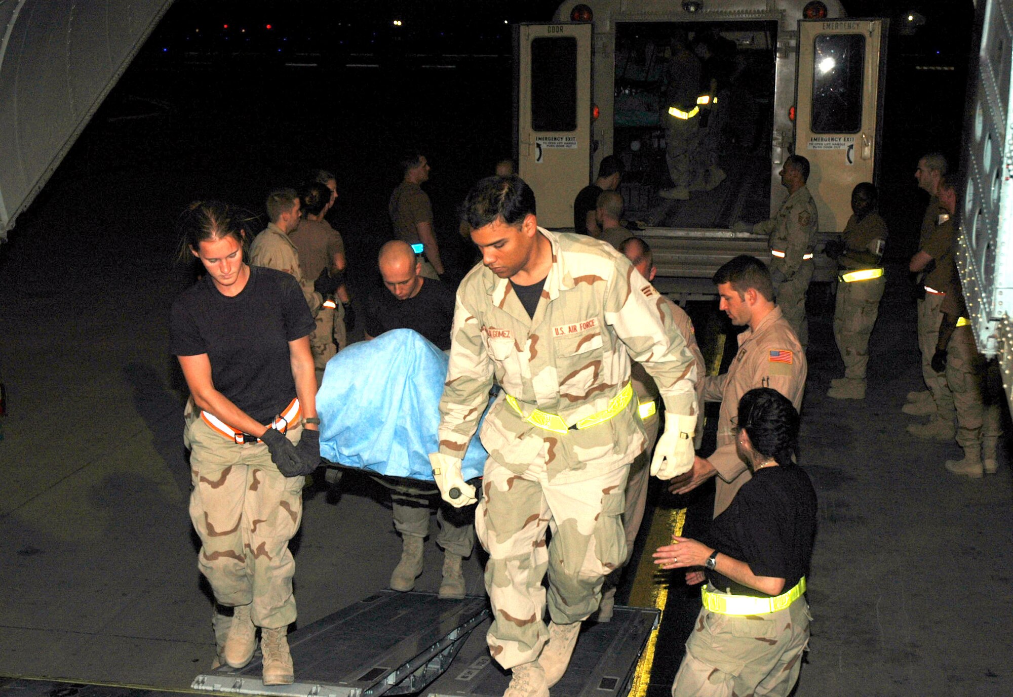 BALAD AIR BASE, Iraq -- Volunteers here help Airmen with the 332nd Expeditionary Medical Group's contingency aeromedical staging facility move patients onto ambulance-type buses equipped with necessary medical supplies.  (U.S. Air Force photo by Senior Airman Chawntain Sloan)