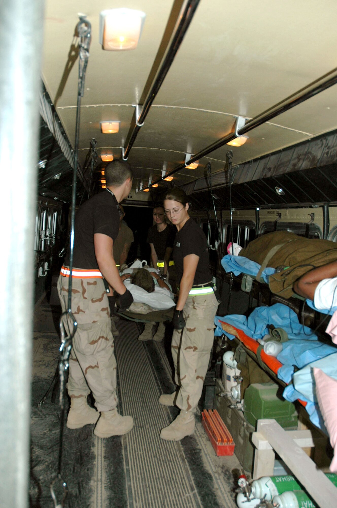 BALAD AIR BASE, Iraq -- Volunteers help Airmen with the 332nd Expeditionary Medical Group's contingency aeromedical staging facility move patients onto ambulance-type buses equipped with necessary medical supplies.  (U.S. Air Force photo by Senior Airman Chawntain Sloan)