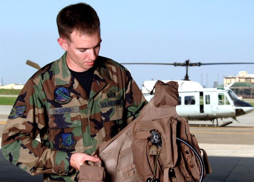 YOKOTA AIR BASE, Japan -- Staff Sgt. Brian Higgins prepares life-support equipment before a UH-1N Huey helicopter mission.  He is a life-support technician with the 459th Airlift Squadron here.  U.S. Air Force photo by Master Sgt. Val Gempis)
